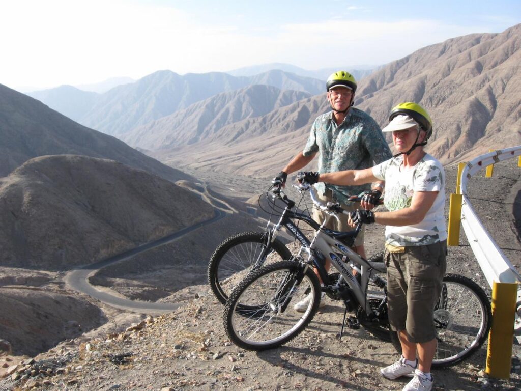 Two cyclists posing during a mountain bike tour in the Nasca desert, Peru